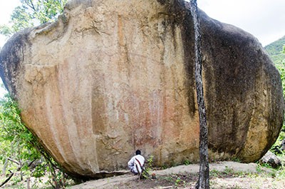 Elephant panel of rock art. The squatting human for a sense of scale and you can just barely see the outline of the top of the elephant.