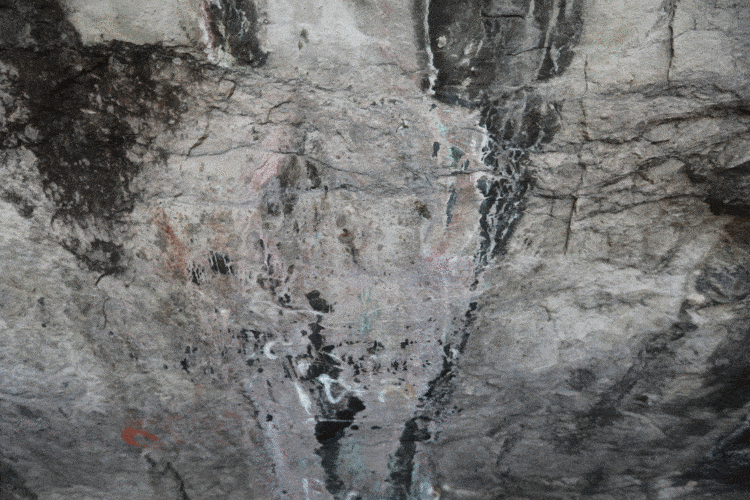New Buddhist rock art at Wat Phraphuttachai, practically invisible to the naked eye. Only parts of the "wings" can be seen easily.