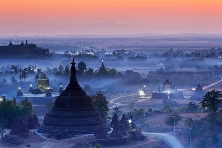 View from hazy sunset over silhouette Ratanabon Paya in Mrauk-U, Myanmar